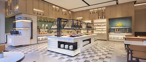 Una cocina moderna con una isla central, electrodomésticos integrados y suelo de cuadros.
