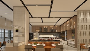 Un comedor moderno con una isla central, asientos y una cocina al fondo.