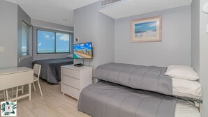 A bedroom with a bed, a desk, a chair, a TV, and a window with blinds. - 9th floor Studio with Incredible Views @ Myrtle Beach Resort (Myrtle Beach)