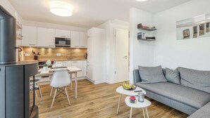 Un appartement moderne comprenant une cuisine, un coin repas et un salon.
