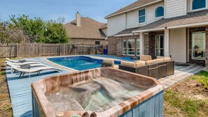 A backyard with a swimming pool, hot tub, and outdoor seating area. - Home with private pool rents for longer term stay (Cedar Park)