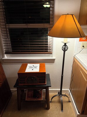 Ein Holzradio auf einem Tisch, eine Lampe mit weißem Schirm und ein Schild, das Ruhezeiten anzeigt.