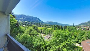 A balcony overlooking a mountainous landscape with houses and greenery. - 1 RC Gentianes - (Megève)
