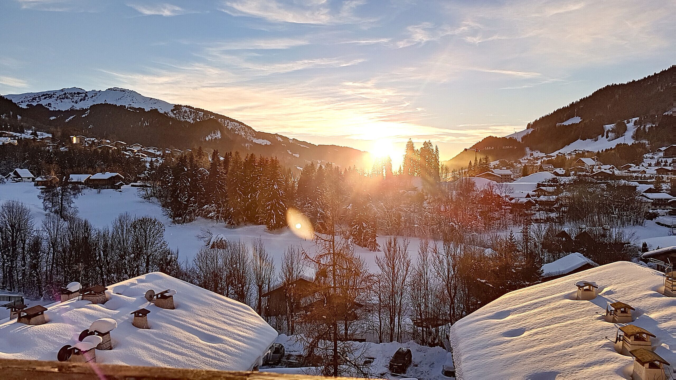 A snowy mountain landscape with cabins and a clear sky.