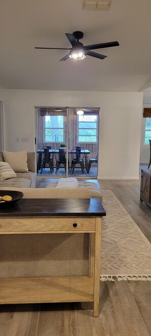 Un salon spacieux avec une table basse en bois, un canapé et un coin repas comprenant des chaises et une table.