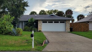Une maison d’habitation avec un garage, une cour avant avec une boîte aux lettres et une allée.