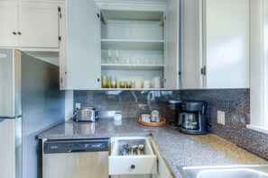 Een keuken met een vaatwasser, een koffiezetapparaat en een lade-organizer.