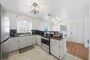 A modern kitchen with white cabinets, a built-in oven, and a granite countertop.