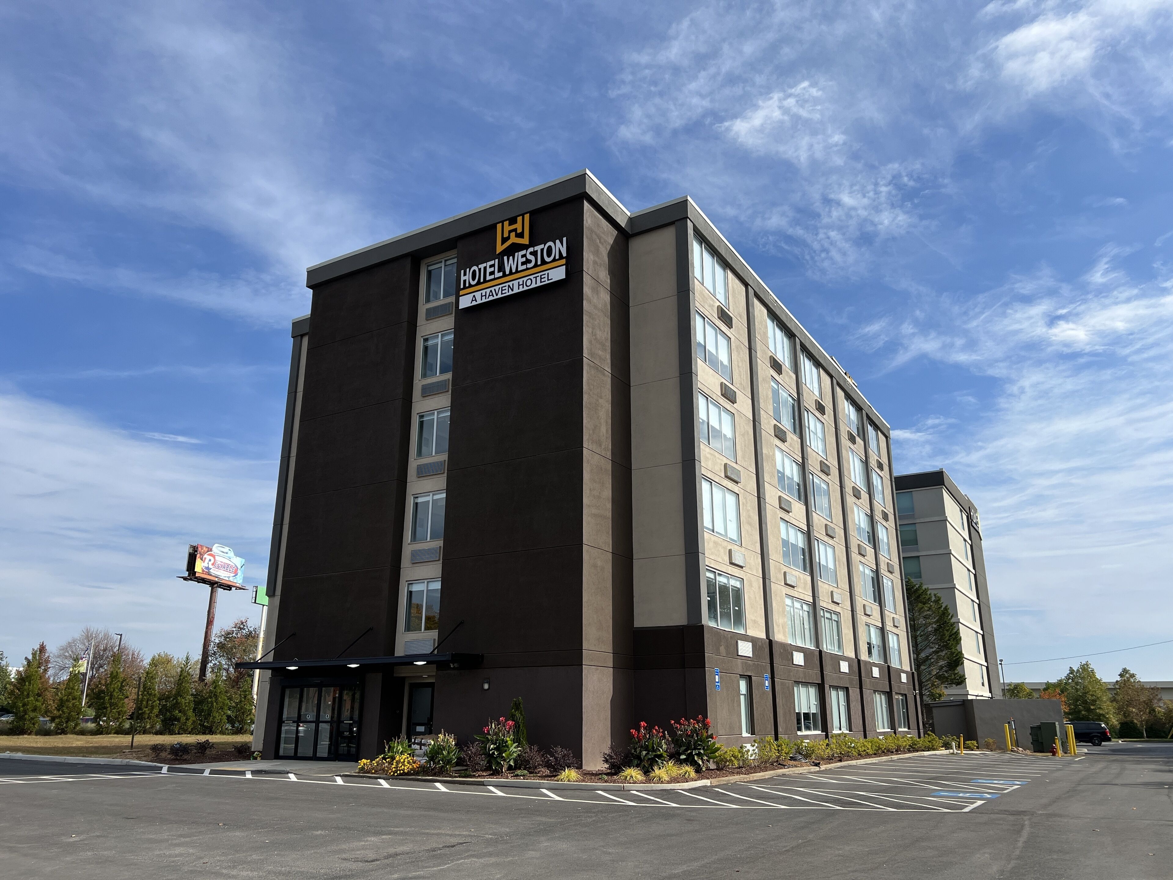 A multi-story hotel building with a sign reading "Hotel Weston" and "A Haven Hotel".