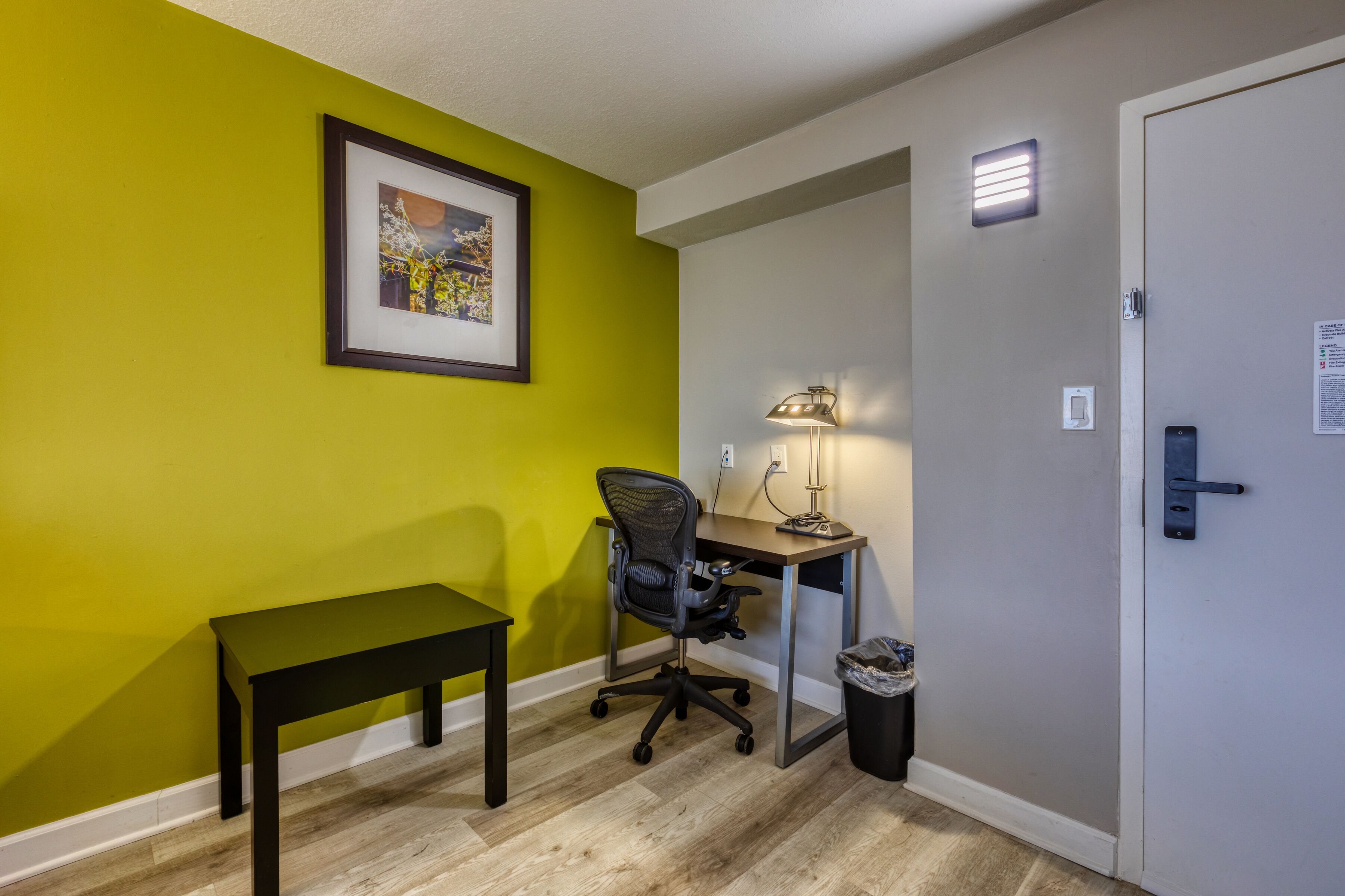 A room with a desk, chair, and bench.