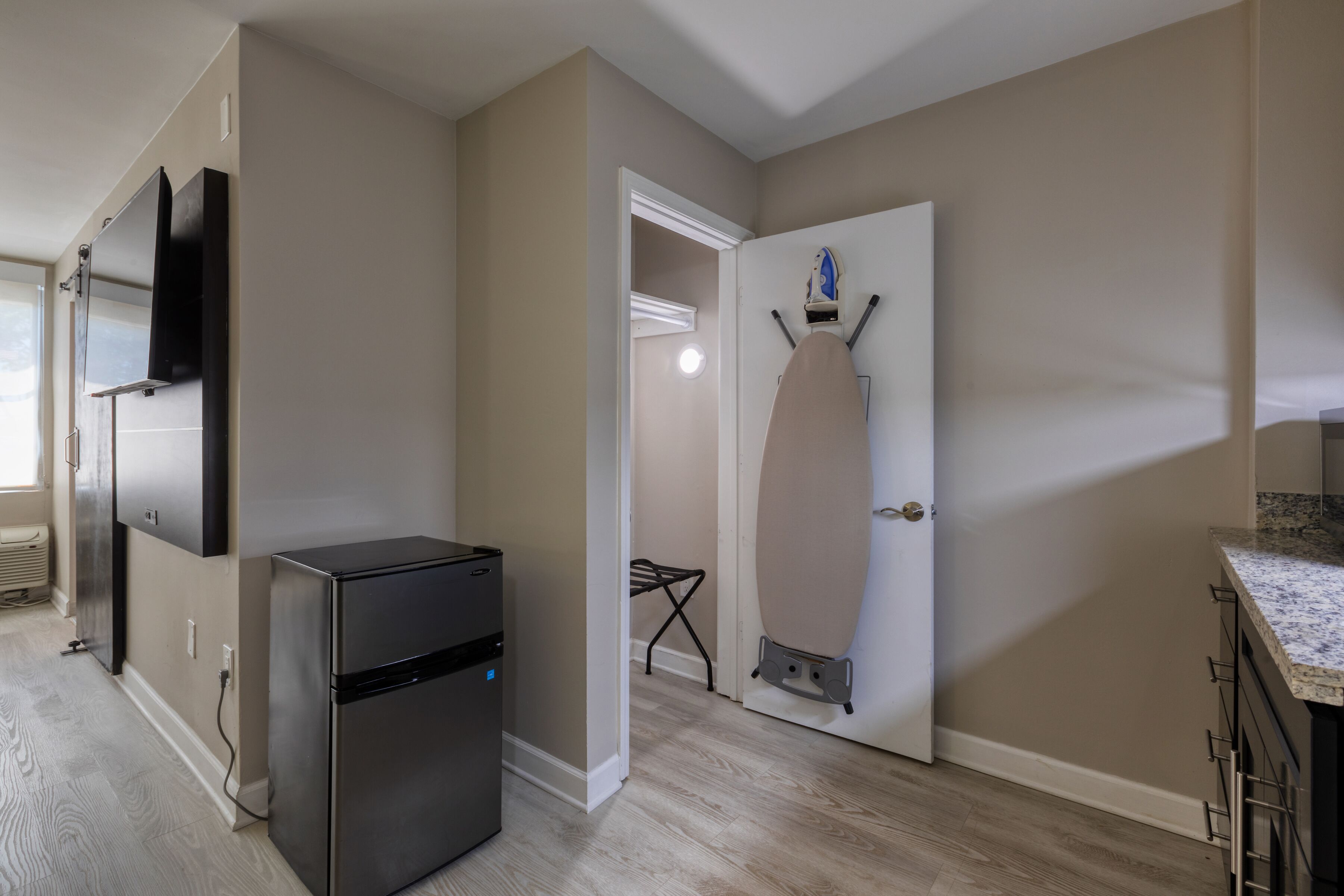 A compact kitchen with a refrigerator, a microwave, and a countertop.