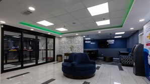Eine moderne Lobby mit einem blauen Sofa, einem Empfangsbereich und einer Wand mit Muster.