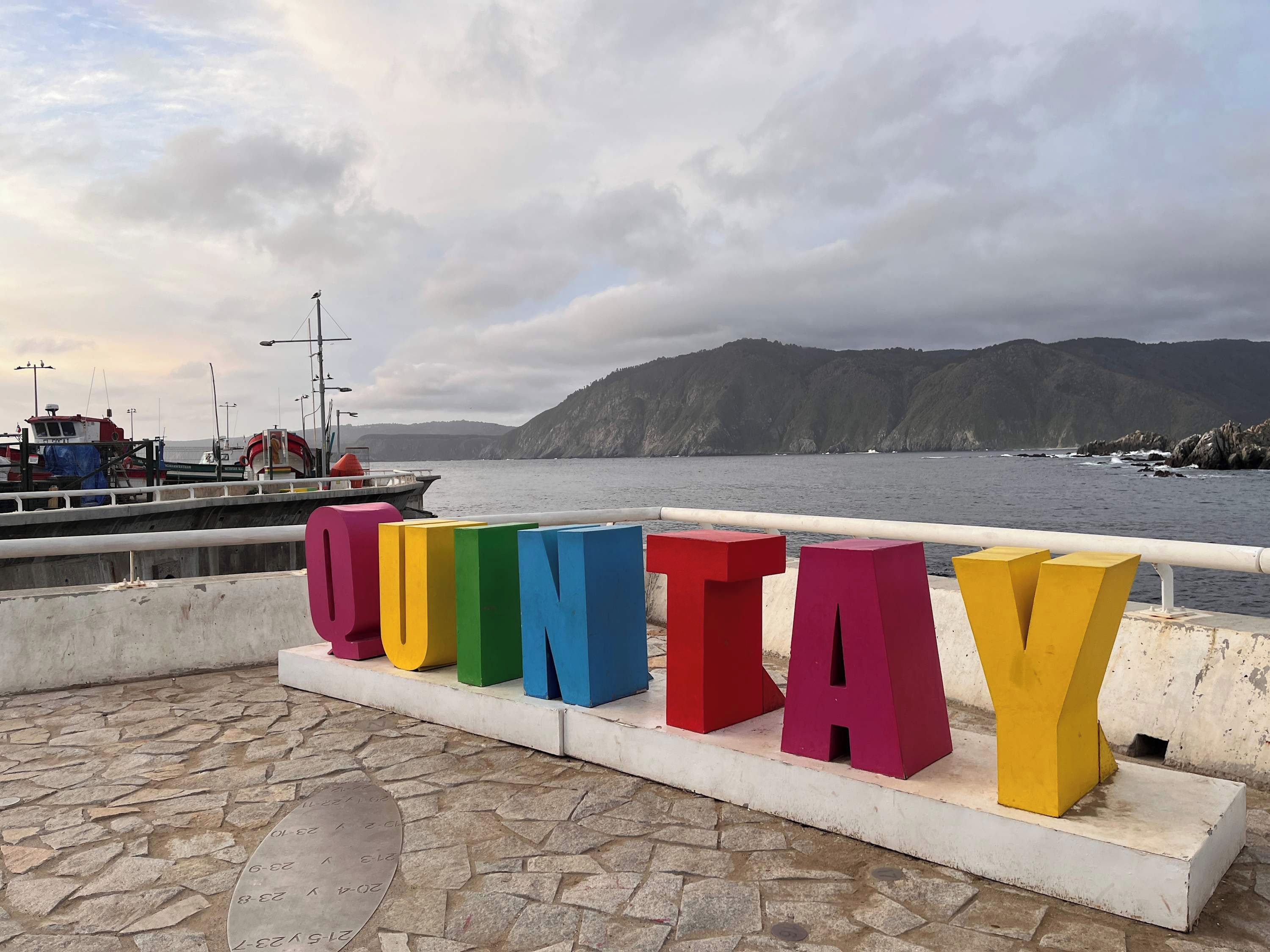 A waterfront view with the word 'QUINTAY' spelled out in colorful letters.