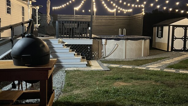 Une terrasse sur le toit équipée d’un barbecue, de meubles d’extérieur et de guirlandes lumineuses.