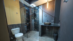 Une salle de bain moderne équipée de toilettes, d’une douche et d’un lavabo.