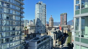 A high-rise urban area with modern architecture, including a prominent building with a dome and another with a unique curved design. - The Designist: Downtown Apt with Water Views, Pool, Parking, AC (Vancouver)