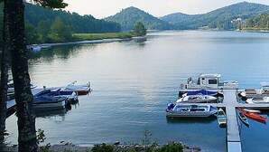 Ein ruhiger See mit mehreren Booten, die an einer Mole festgemacht sind.