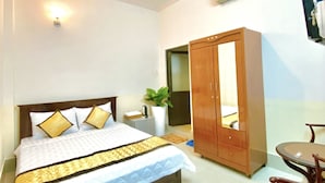 A bedroom with a bed, a wardrobe, a desk, and a chair. - Nama Hotel (Can Tho)