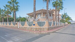 A Mediterranean-style villa with a central courtyard, surrounded by a stone wall and palm trees. - 2Bed Apartment - Sleeps 5 - Pool, Parking, Pets (BENFERRI)