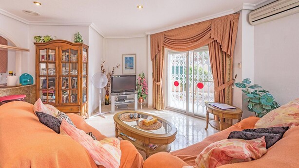 A living room with a sofa set, a wooden cabinet, a television, and a fan. - 2Bed Apartment - Sleeps 5 - Pool, Parking, Pets (BENFERRI)