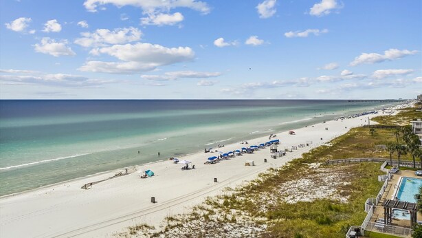 A beach with a long pier extending into the ocean, a sandy beach with umbrellas, and a pool area with a deck. - Cozy Gulf View Studio in Panama City Beach, perfect for 3 guests. (Panama City Beach)