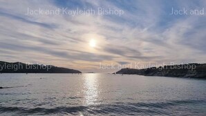 A calm body of water with a clear sky and distant landforms. - 3 Bedroom Holiday Home in Newquay - Valley Views (Newquay)