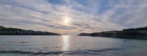 A calm body of water with a clear sky and distant landforms. - 3 Bedroom Holiday Home in Newquay - Valley Views (Newquay)