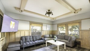 Ein Wohnzimmer mit einem Ecksofa, einem Couchtisch und einer Pendelleuchte.