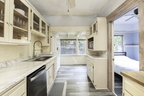 Enjoy cooking in this well-equipped kitchen with a dishwasher, stainless steel sink, and ample natural light.
