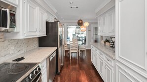 A modern kitchen with white cabinetry, a built-in microwave, and a stainless steel refrigerator. - Luxury Lakefront - Game Room - 7 beds - Hot tub - Kayaks - Dock (Montgomery)