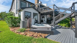 A modern house with a hot tub, outdoor stairs, and a deck. - Luxury Lakefront - Game Room - 7 beds - Hot tub - Kayaks - Dock (Montgomery)