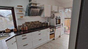 A modern kitchen with white cabinets, a black countertop, and a skylight. - Vacation apartment Biene (Saarbrücken)