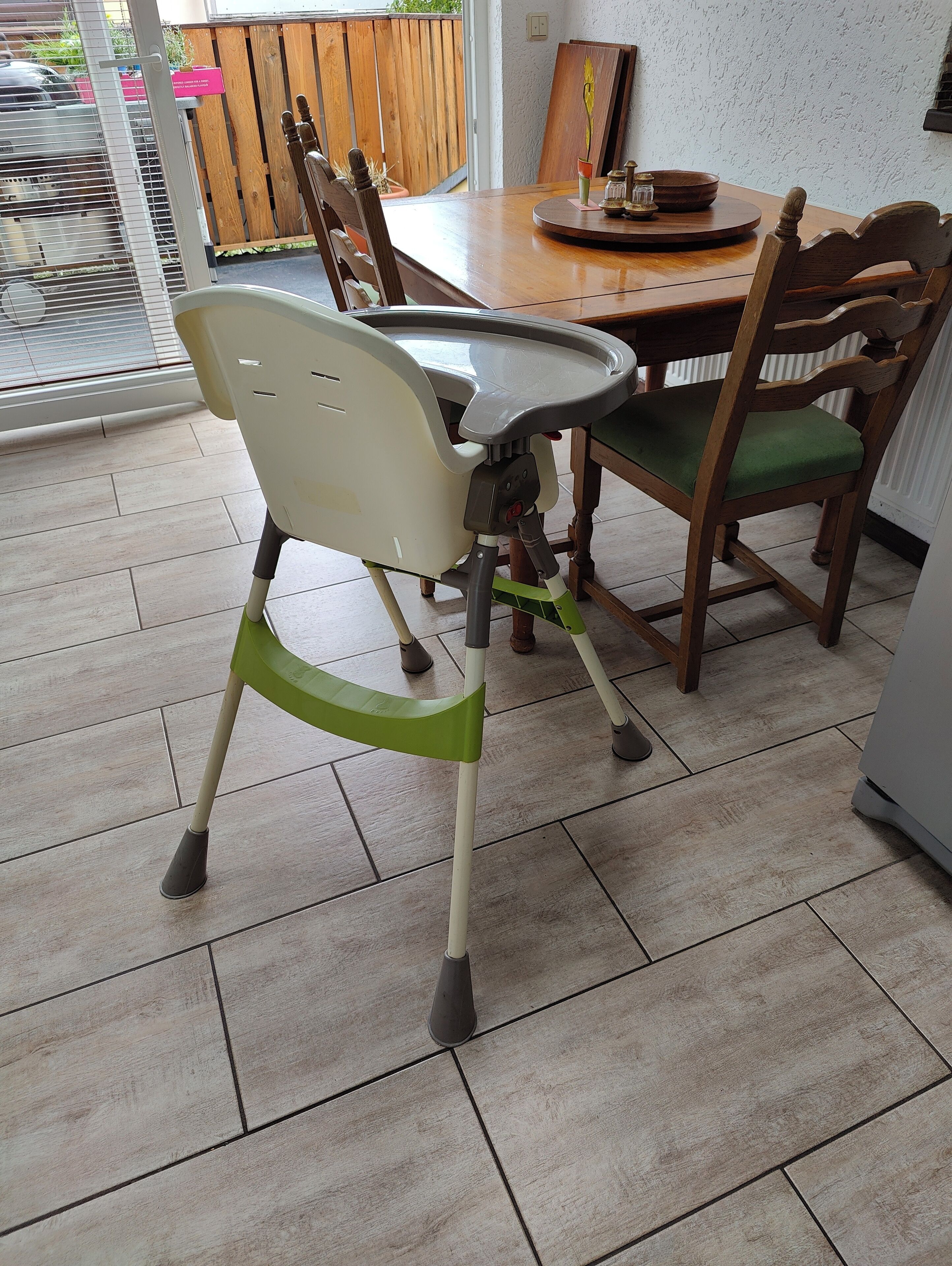 A dining area with a table, chairs, and a high chair.