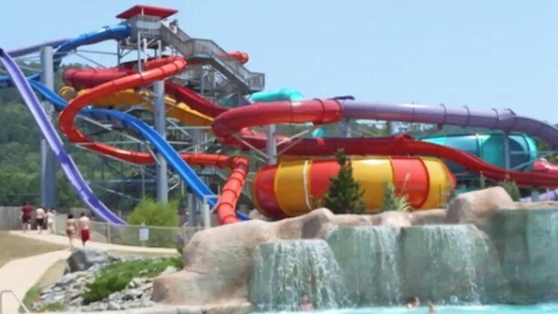 Een waterpark met meerdere glijbanen en een zwembad.