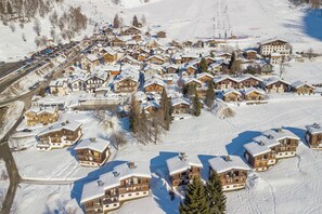 A snow-covered village with wooden buildings, a ski slope, and a road. - Le Bellevue 04 Argentière Village Walk to Lifts & Pool, Argentière (Chamonix), France (Argentière (Chamonix))