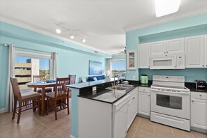 Enjoy meals in the kitchen with a central island, sink, and oven, and dine in the adjacent area with a table and chairs.