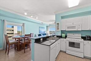 Enjoy meals in the kitchen with a central island, sink, and oven, and dine in the adjacent area with a table and chairs.