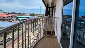 A balcony with a view of a busy street and buildings in the background. - Wing Tat Grand Hotel (Semporna)