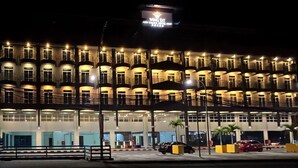 A multi-story hotel with a prominent sign reading "Wing Eat Grand Hotel." - Wing Tat Grand Hotel (Semporna)