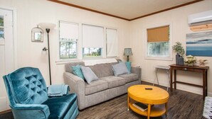 Una sala de estar acogedora con un sofá gris, un sillón azul y una mesa de centro de madera.