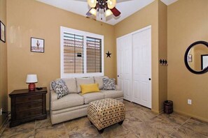 Cozy living space with a sofa, nightstand, and mirror.