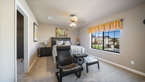 A bedroom with a bed, a desk, a chair, a nightstand, a window with a view, and a ceiling fan. - South Mountain Retreat - Free Heated Pool, Tesla outlet, RV Parking (Phoenix)