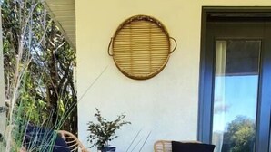 A covered patio area with two wicker chairs and a potted plant. - On Golf Course | Peaceful | Central | Upscale (Columbus)