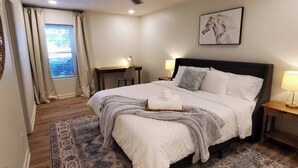 A bedroom with a bed, a desk, a chair, a ceiling fan, and a window with curtains. - On Golf Course | Peaceful | Central | Upscale (Columbus)
