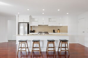 Enjoy cooking in this well-equipped kitchen with a central island, stove, and ample cabinetry.