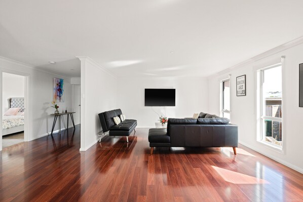 Relax in this stylish living room with a comfortable sofa, flat-screen TV, and beautiful artwork.