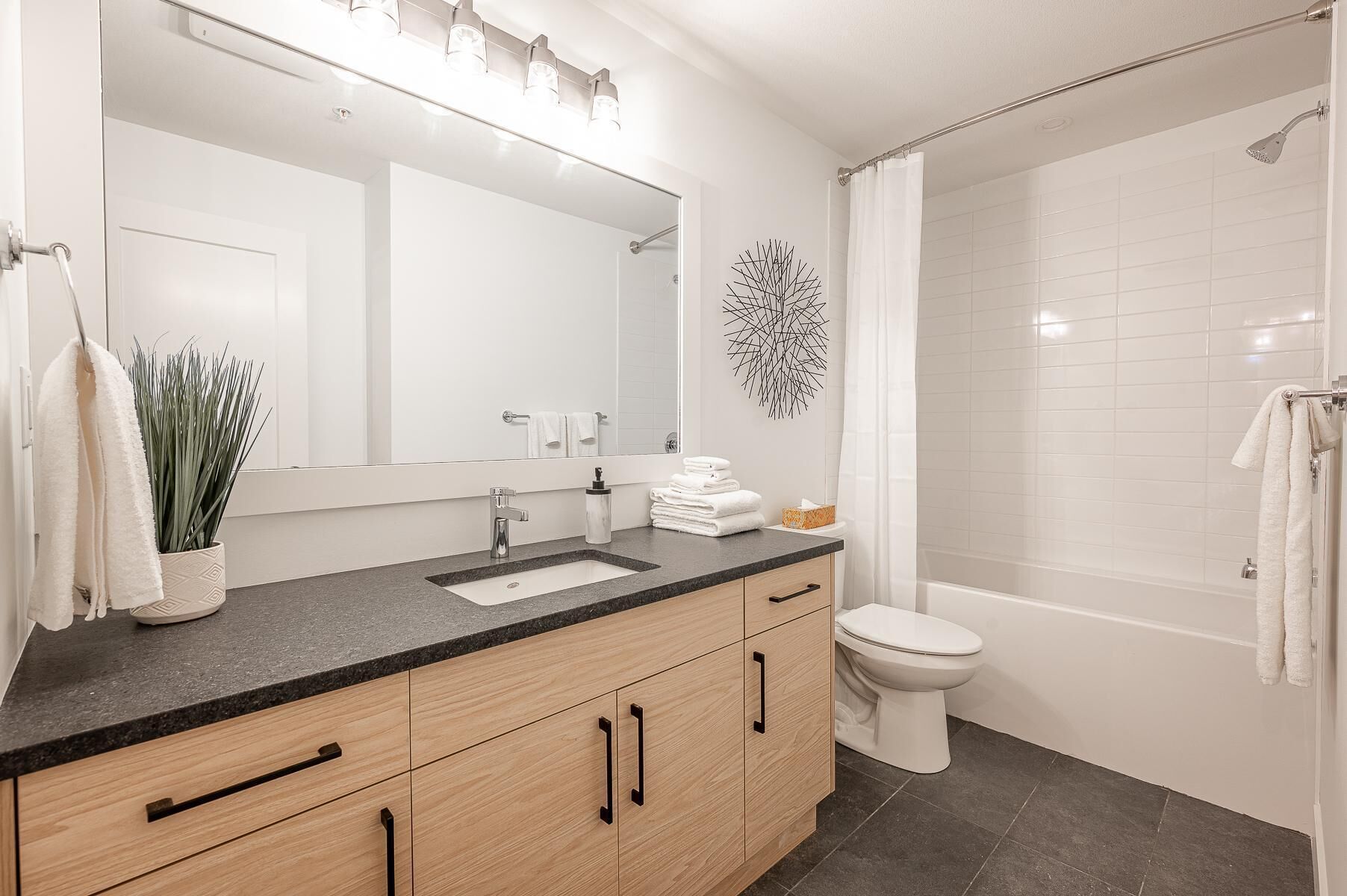 Une salle de bain moderne avec un lavabo, un miroir et des toilettes.