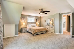 A bedroom with a bed, nightstands, a ceiling fan, a window, and a door. - Sunny Glen Burnie Home - On-Site Water Access (Glen Burnie)