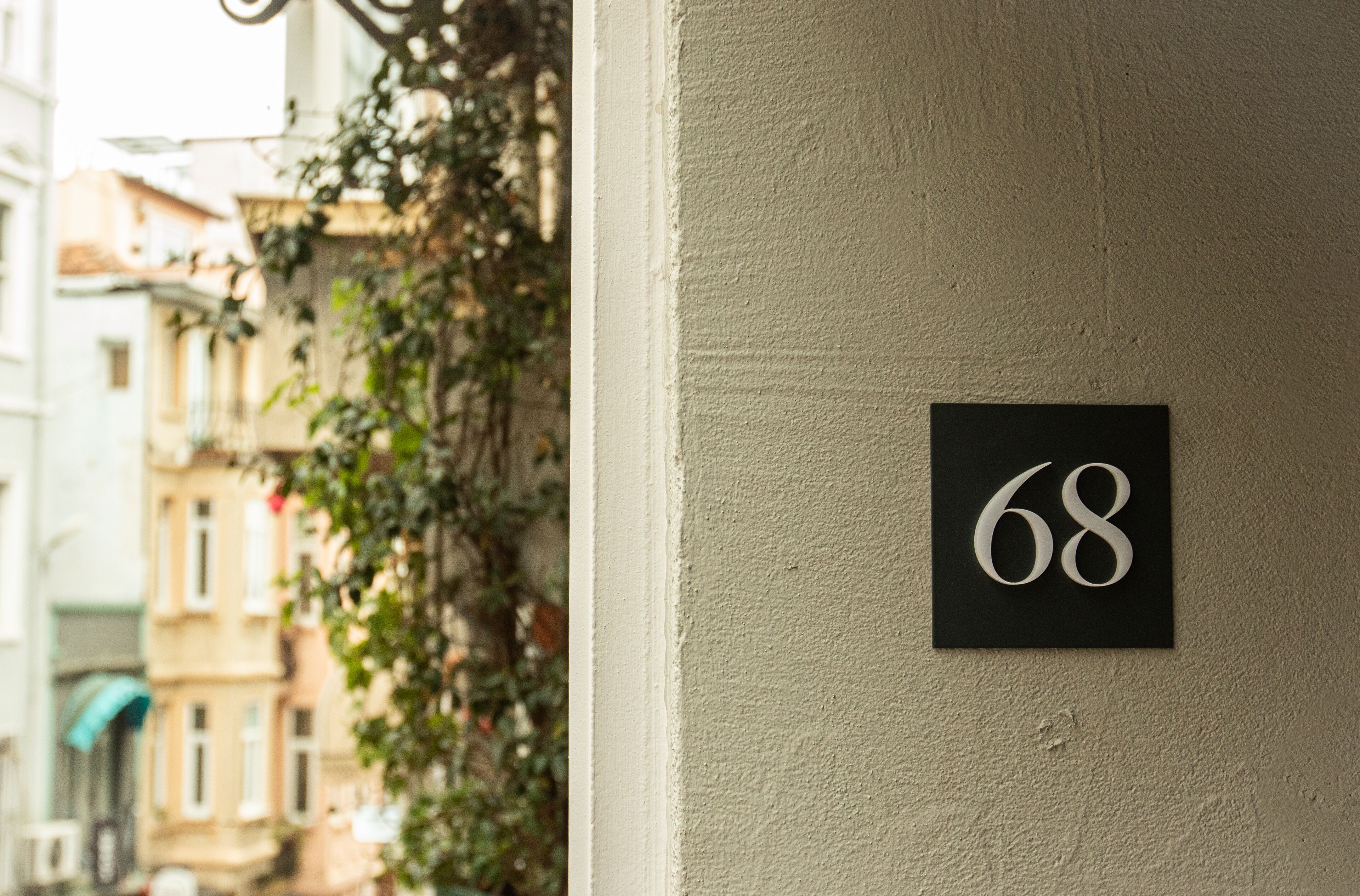 Une façade d’immeuble avec un panneau portant le chiffre « 68 » sur un mur.