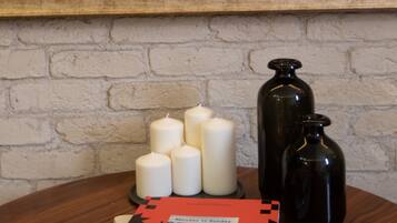 A table with candles, a book titled "ISTANBUL," and a vase with flowers.